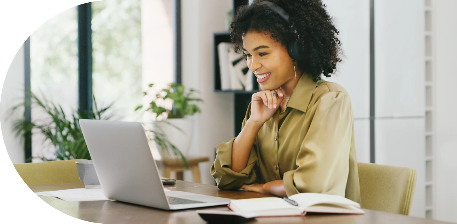 woman wearing headphones and using a laptop on a desk