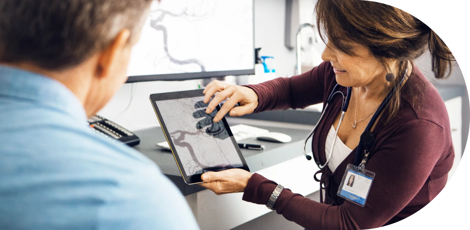 woman nurse showing tablet to man